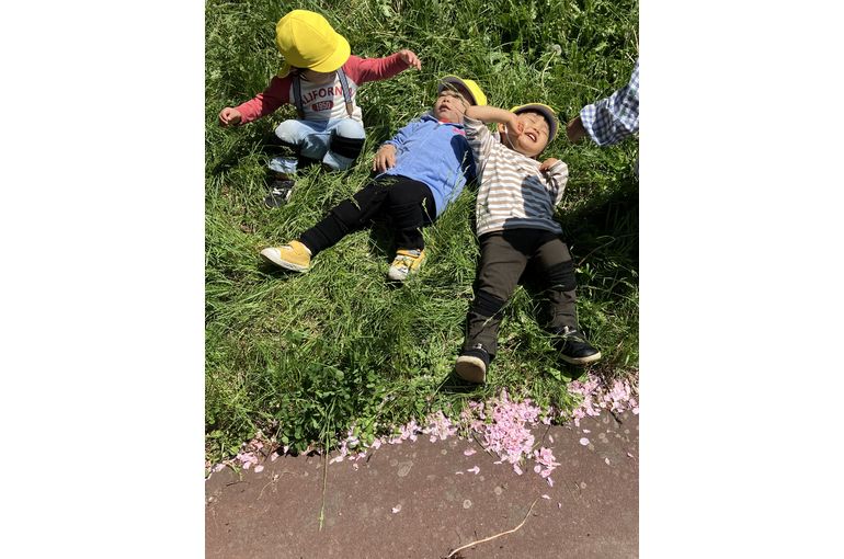 草原に寝転がる子供たち