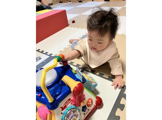 ハイハイしておもちゃに向かうこども