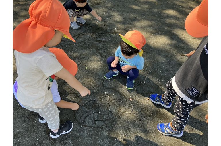 地面にお絵描きする子ども