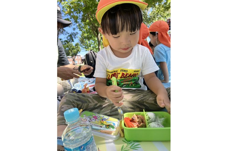 弁当を頬張るこども①