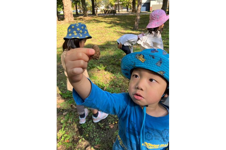 まつぼっくりをもつこども